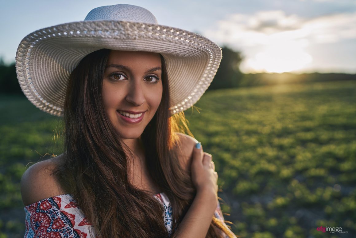 beautiful young girl in field at sunset