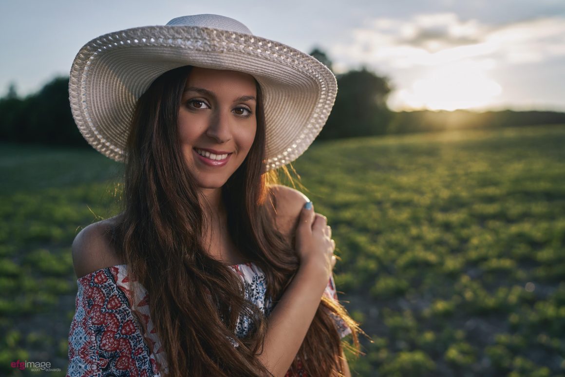 beautiful young girl with white hat in field