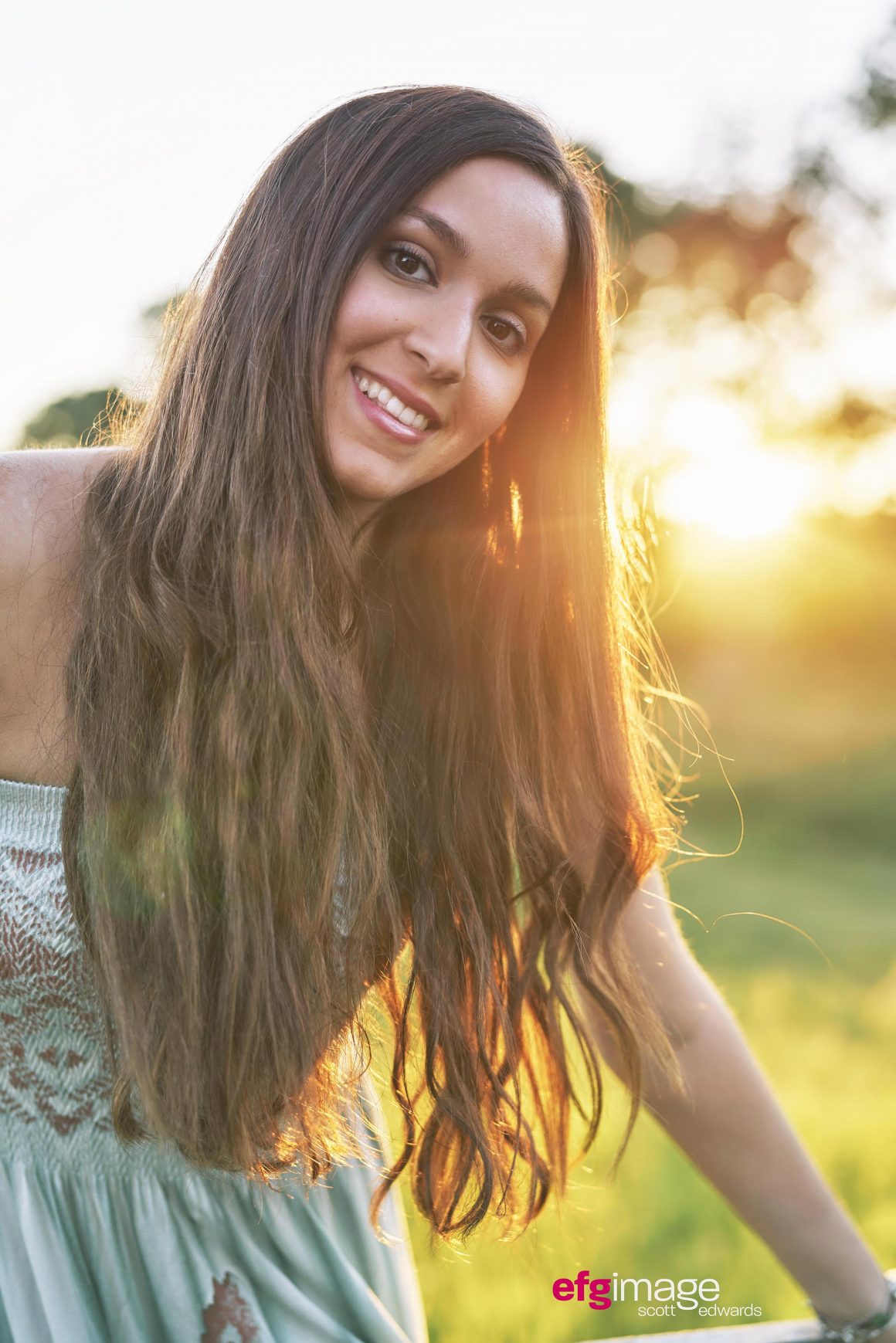 Beautiful girl smiles as sun rays light her hair
