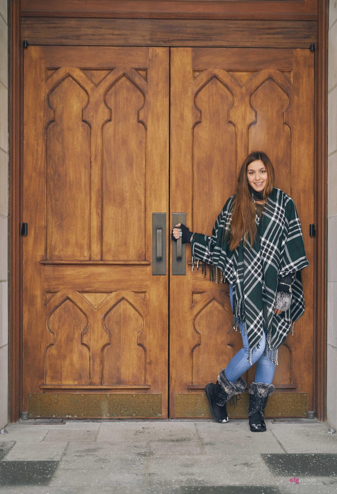 girl stands in front of doors during winter